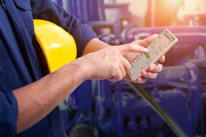 Field technician using a smartphone for mobile work order management in a manufacturing plant