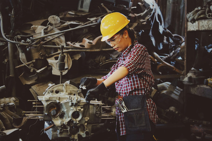 Female engineer in hard hat performing hands-on asset inspection to support EAM ROI measurement and maintenance planning