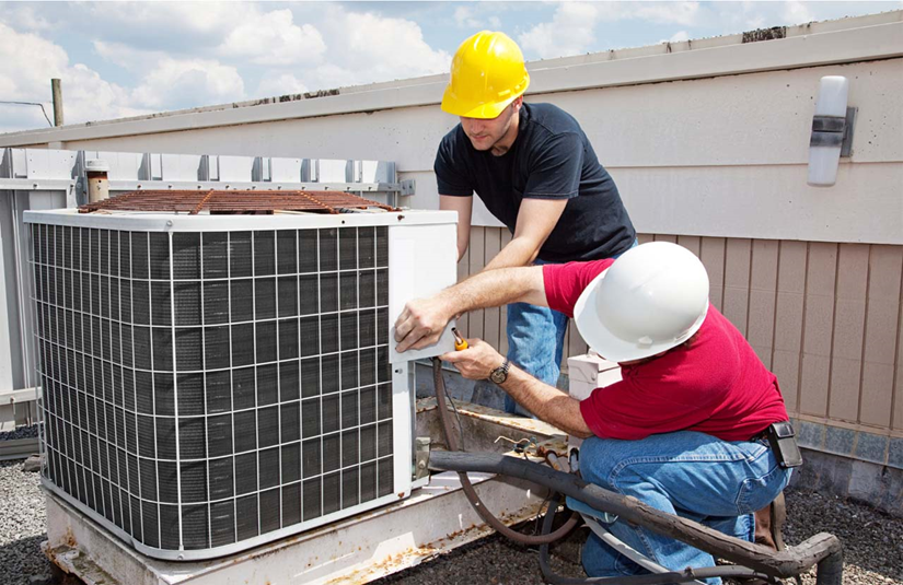 Commercial HVAC maintenance technicians performing condition-based predictive maintenance on rooftop units